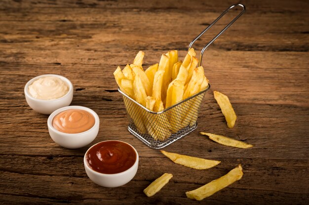 Frieten met sauzen op rustieke houten achtergrond