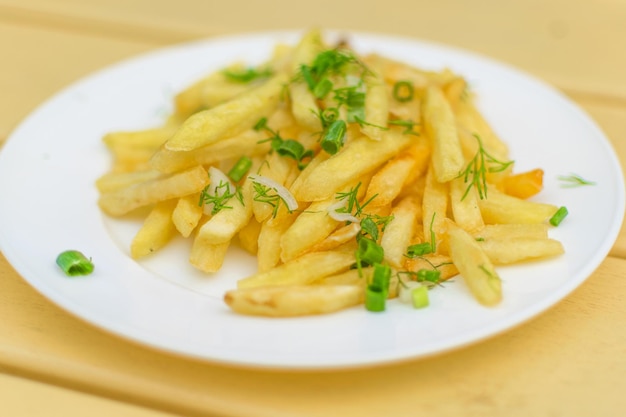 Frieten op een bord op een gele houten achtergrond