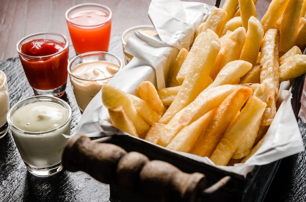 frietjes in de mand met saus dompelen