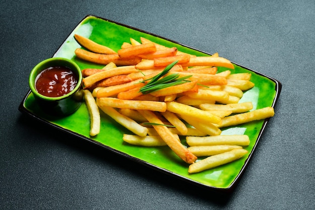 Frietjes met ketchup op een bord op een donkere achtergrond close-up