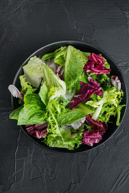 Frieze, romaine and Radicchio lettuce salad, on black background, top view flat lay
