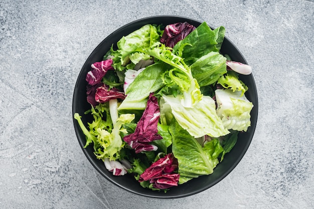 Insalata di lattuga fregio, romana e radicchio, su sfondo grigio, vista dall'alto piatta