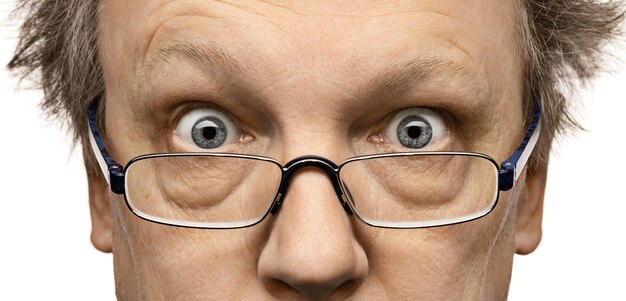 Frightened eyes of a middleaged man in glasses Closeup macro photo black background