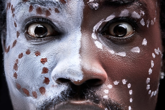 Frightened man with ethnic paintings on face