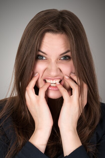 Frightened and stressed young business woman biting her fingers