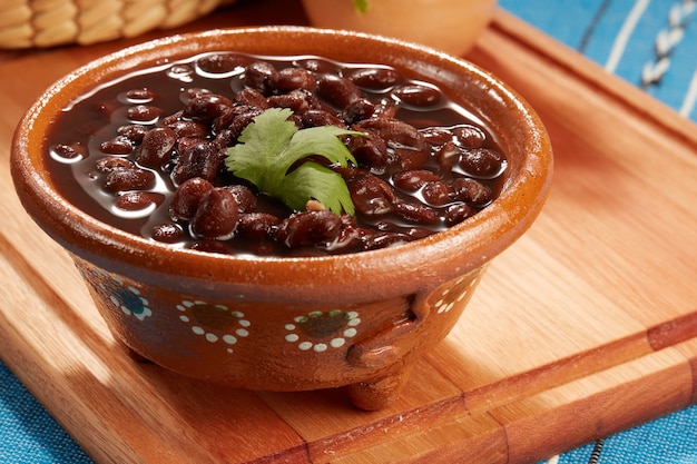 Фото frijoles negros mexicanos servidos en plato de barro comida mexicana