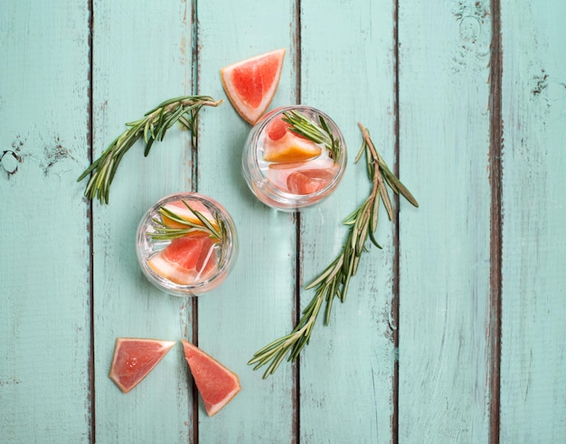 Fris drankje met grapefruit en rozemarijn op blauwgroene shabby chique achtergrond