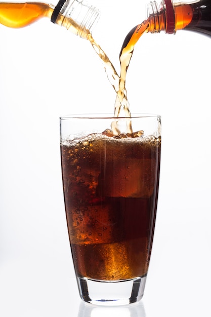 Frisdrank en alcohol vullen een glas met ijsblokjes