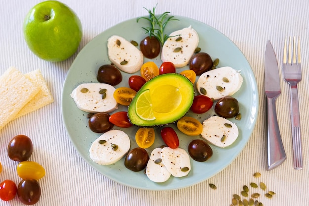 Frisse caprese salade Een gerecht met kaas mozzarella en cherrytomaatjes peper en pompoenpitten