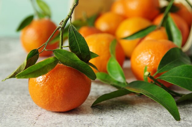 Frisse geurige mandarijnen. Rijpe sappige mandarijnen met groene bladeren op tafel.