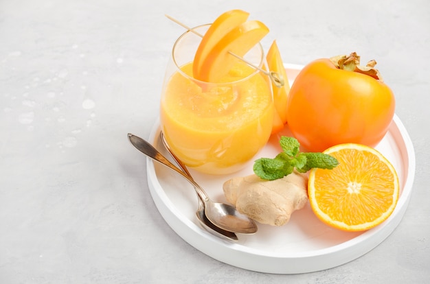 Frisse gezonde smoothie met persimmon, sinaasappel en gember.