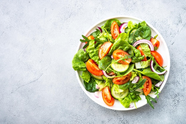 Frisse groene salade met bladeren en groenten Top uitzicht op stenen tafel