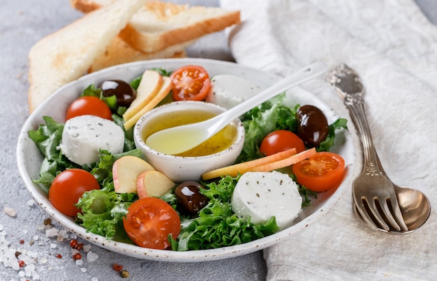 Frisse, heerlijke geitenkaassalade met sla, cherrytomaatjes, appel, olijven van Kalamata