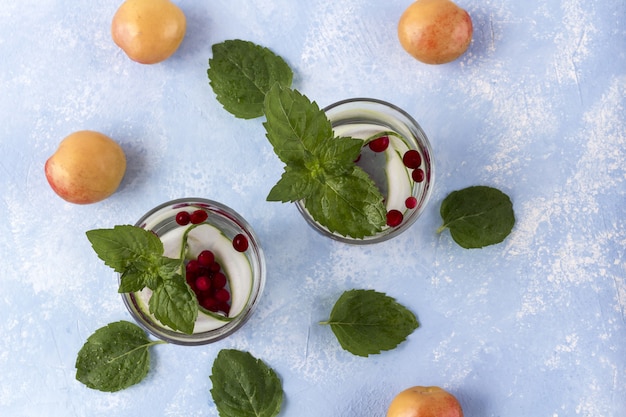 Frisse koele detoxdrank met komkommer, bessen en perziken of aprikotes.