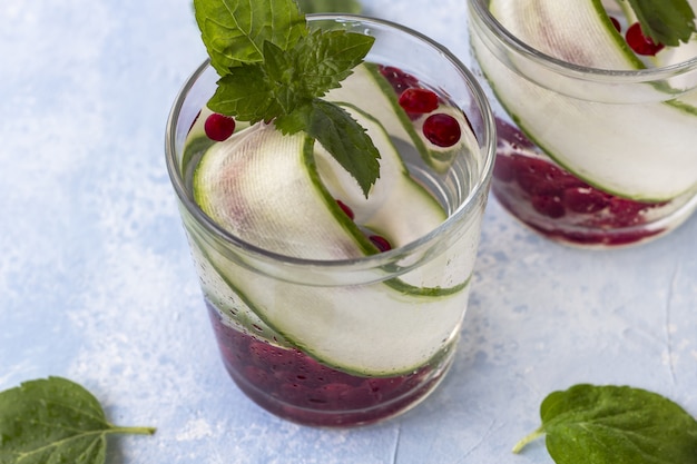 Frisse koele detoxdrank met komkommer en bessen, limonade in een glas met een munt