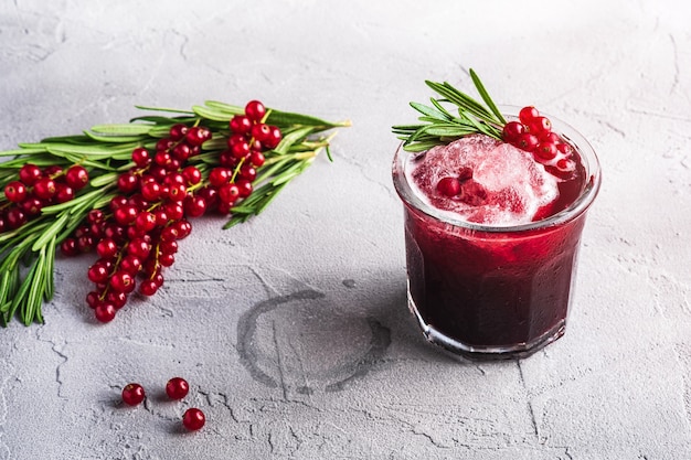 Frisse koude fruitcocktail in glas, verfrissende zomer rode bessen bessen drankje met rozemarijn bladeren