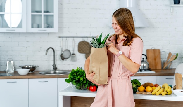 Frisse salade maken in de keuken Mooie schattige dame met vegetarisch eten