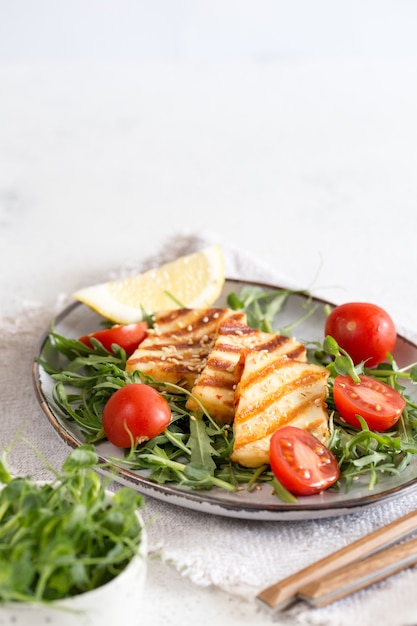 Frisse salade met gegrilde halumi kaas, kerstomaatjes en rucola