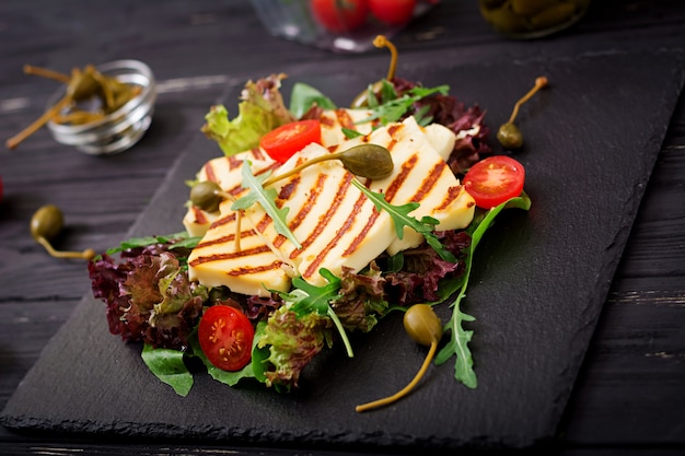 Frisse salade met gegrilde kaas, tomaten, kappertjes, sla en rucola.