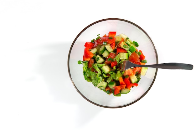 Frisse salade met groenten, tomaten, komkommers, sla, saladebladeren op een witte achtergrond bovenaanzicht en kopieerruimte. Gezond voedsel en dieetconcept. Vegetarisch eten