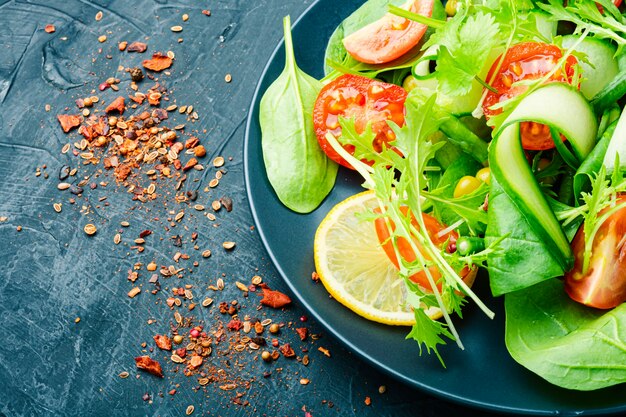 Frisse salade met komkommer, tomaten, kruiden, citroen en hazelnoten.