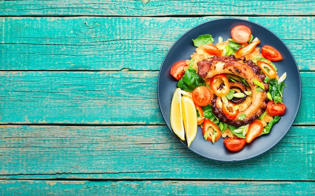 Frisse salade met octopus, paprika, tomaat en greens.Kopieer de ruimte