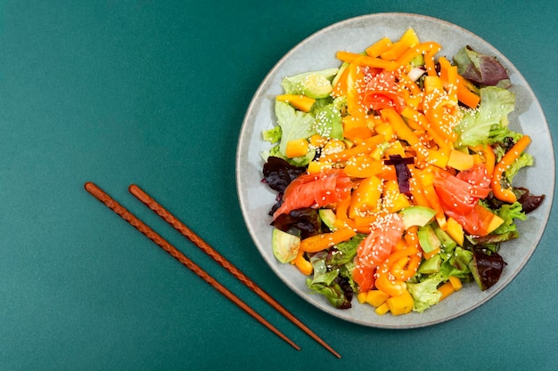 Frisse salade met zalm, mango, sesam en groenten Kopieer ruimte Salade en eetstokjes