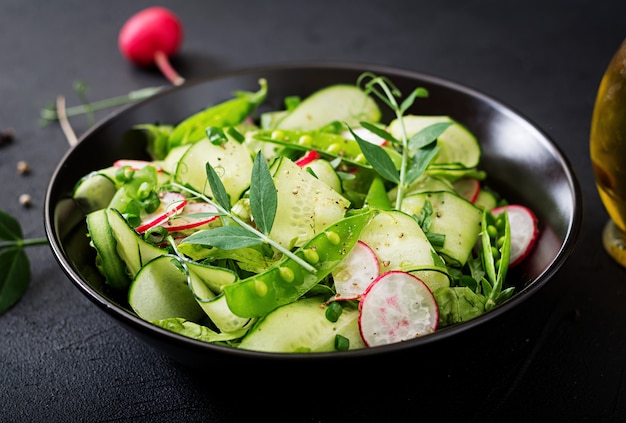 Frisse salade van komkommers, radijs, groene erwten en kruiden