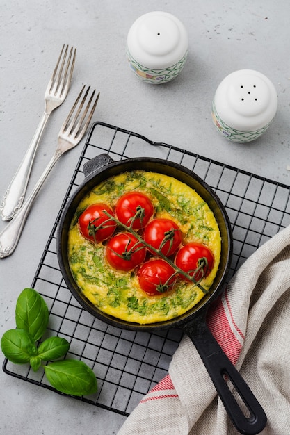 오래 된 돌 테이블에 철 냄비에 Arugula, 감자, 체리 토마토와 Frittata. 평면도.