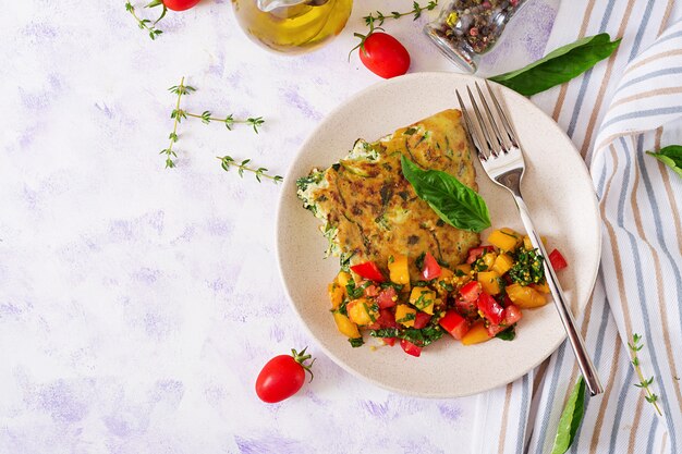 Frittata with zucchini, cheese, basil and salsa from tomatoes. Italian omelette. 