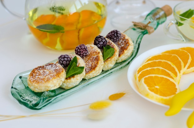 Fritters of cottage cheese with blackberries, mint and sour cream 