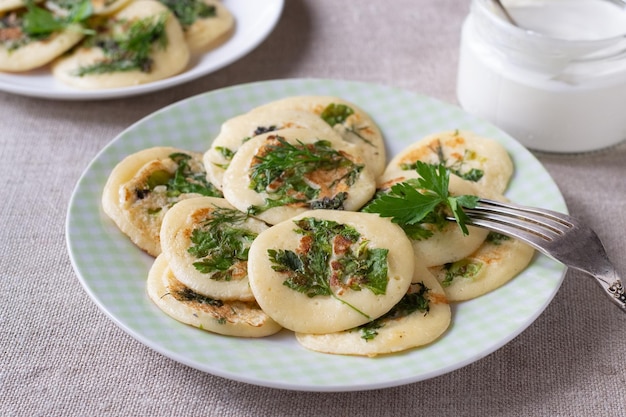 Foto frittelle con prezzemolo verde, aneto, lattuga e panna acida