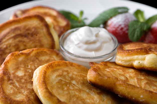 Fritters with sour cream on a plate