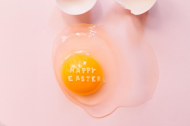 写真 上から生の破れた卵と,黄色い黄色とピンクの背景の卵の ⁇ に