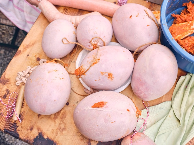 From above of arranged homemade sausage formed in balls in casing of pork guts placed on wooden board