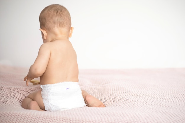 From the back A white diaper on a baby The legs of the child mockup space for text