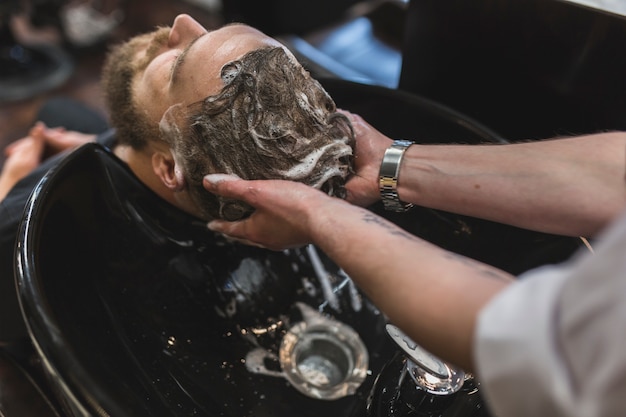 Photo from above barber washing hair of client