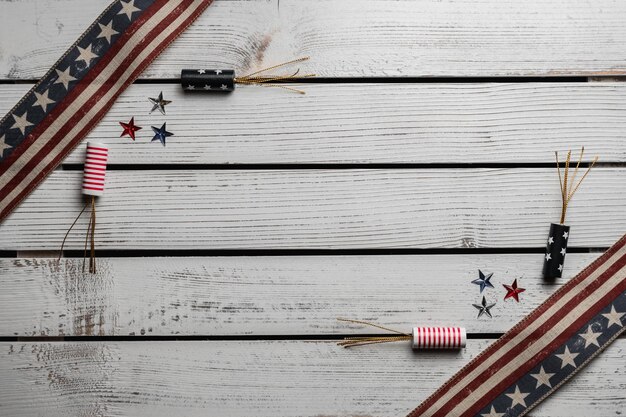 Photo from above of fireworks and tiny multi colored stars between long narrow flags of united states