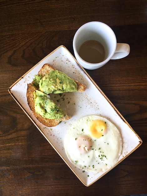 from above healthy breakfast with avocado toast and fried eggs