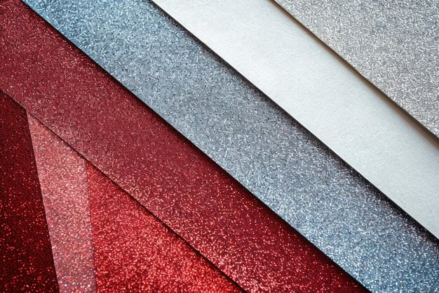 From above layout of pastel glitter cardboard sheets in brown white red and grey shiny shades