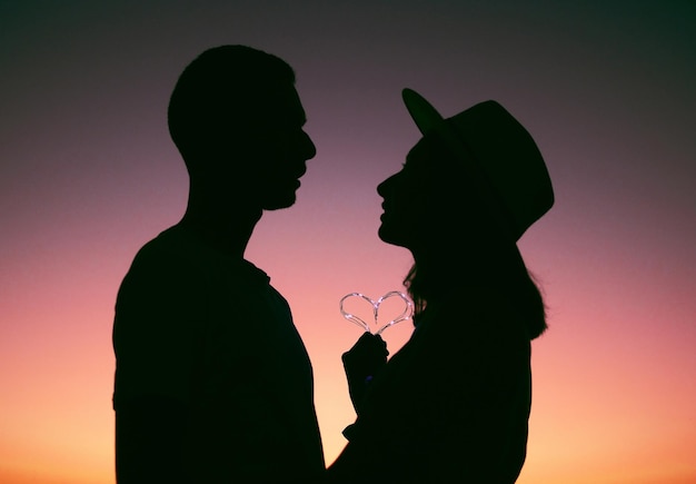 写真 私の心からあなたの心へ日没時にシルエットを描いた愛情のこもった若いカップルのクロップドショット