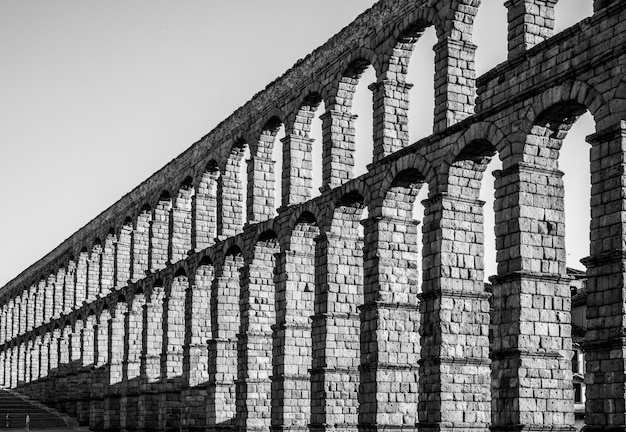 From a perspective with a vanishing point of the arches of the Segovia aqueduct and people on the stairs