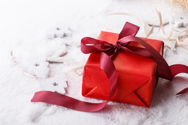 Photo from above shot of bright giftboxes decorated with ribbon and laying on white snow