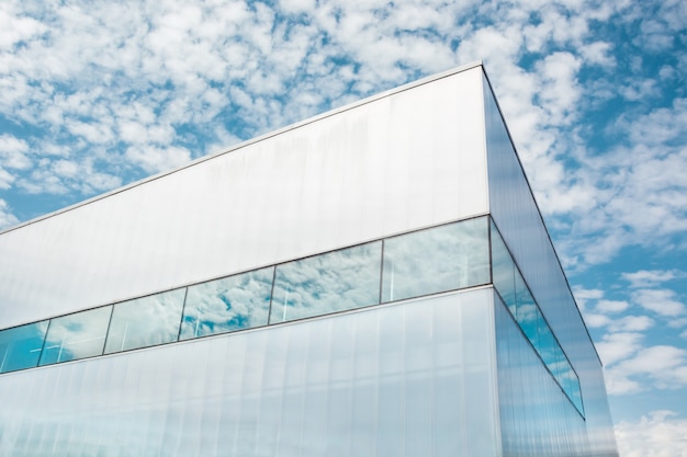 Photo from below shot of shiny glass corner modern business building