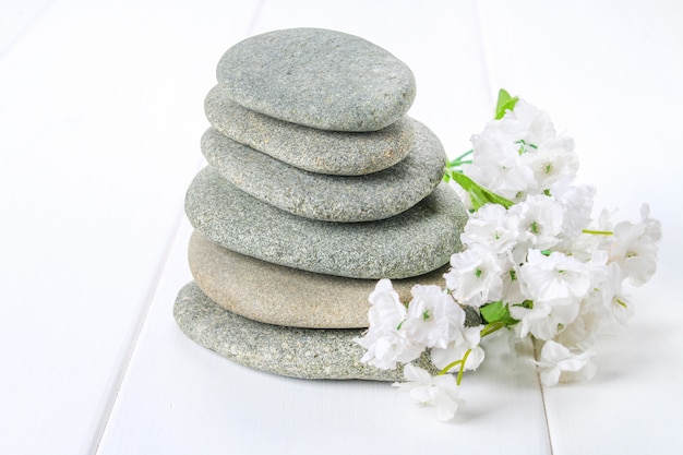 From spa stones make Balances pyramids on white wooden background.