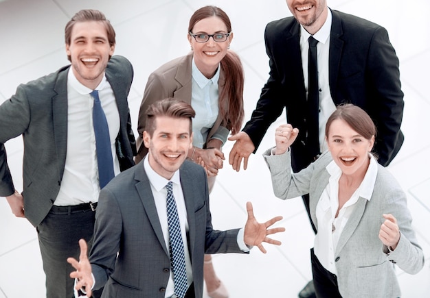 Сверху счастливая бизнес-команда, стоящая в офисе