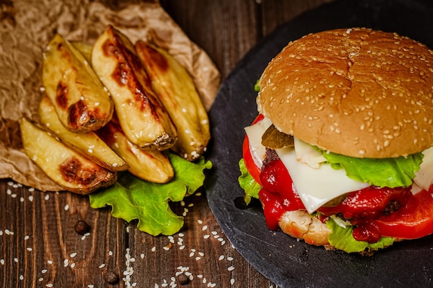 Dall'alto vista hamburger con ketchup di patate e verdure fresche su tavola di pietra cucina casalinga