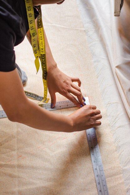 From above woman measuring a piece of fabric