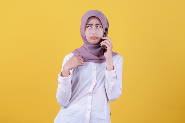 Frons jonge mooie vrouw die door mobiele telefoon belt die hijab draagt