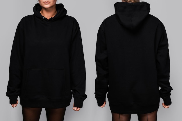 front and back views of a woman wearing a black oversized hoodie with blank space ideal